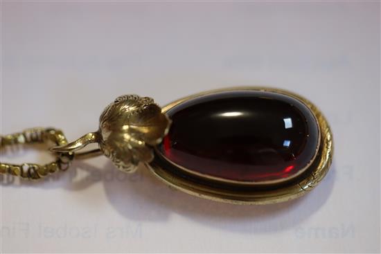 A Victorian gold mounted pear shaped cabochon garnet pendant on oval link chain, pendant 35mm.